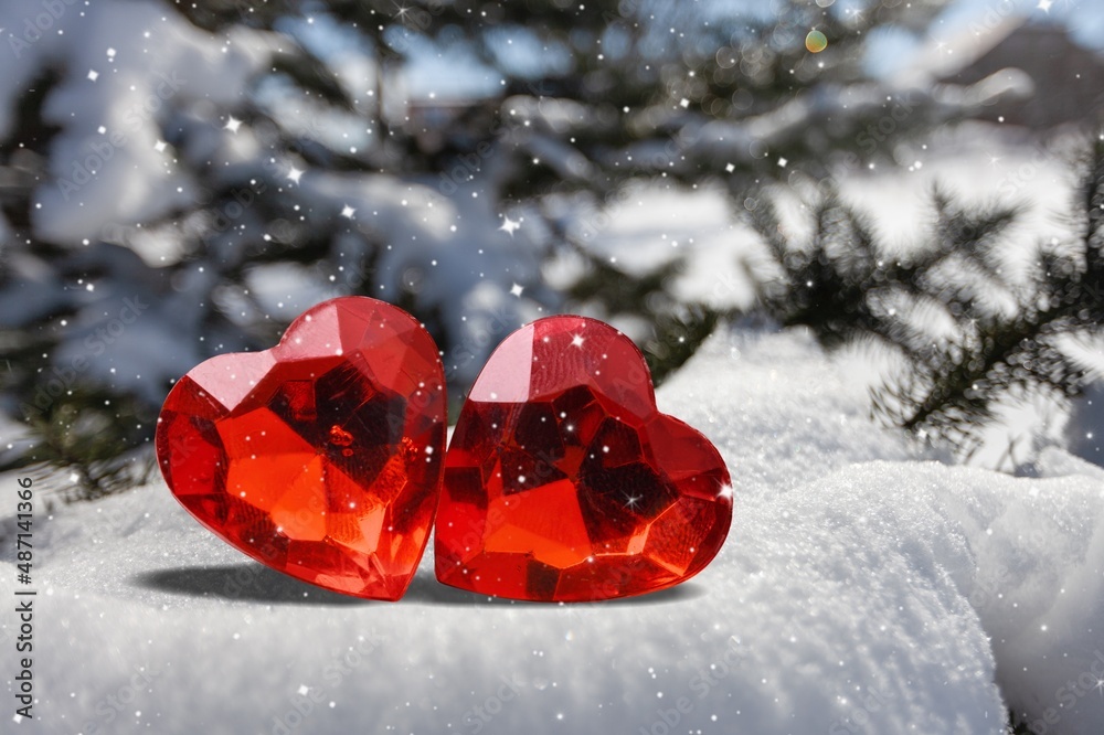 A heart on the snow, blurred forest trees background.Valentine heart in winter forest,