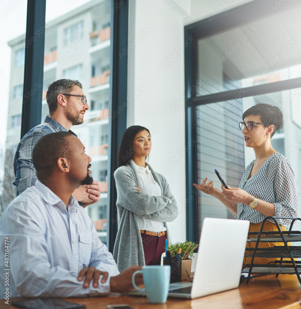 Working together to get the task done. Shot of businesspeople working together in the office.