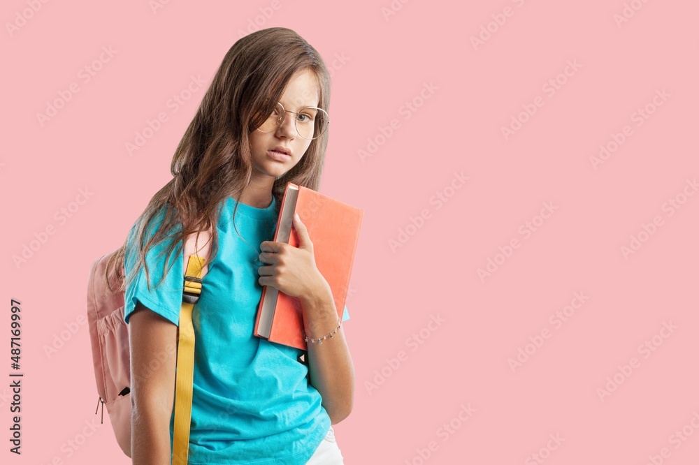 Smiling little smart school girl in casual clothes with backpack