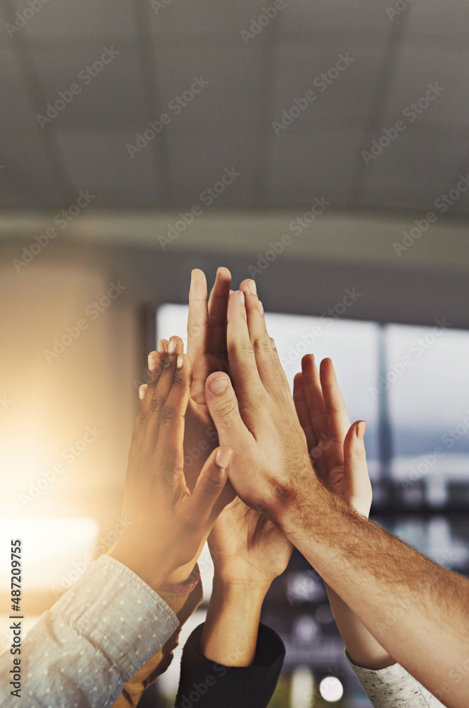 Heres to a job well done. Shot of a group of colleagues giving each other a high five.