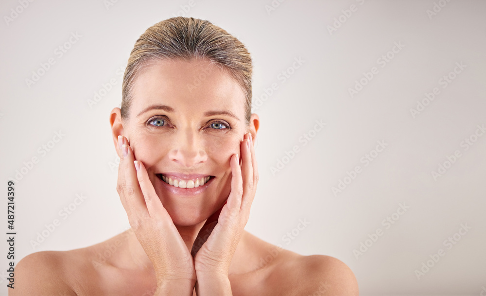 My skin still feels great. Cropped studio portrait of an attractive mature woman touching her skin.