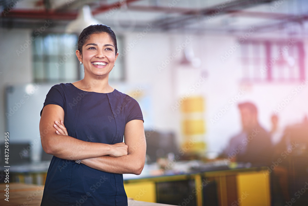 Confident about future success. Shot of an attractive young businesswoman standing with her arms fol