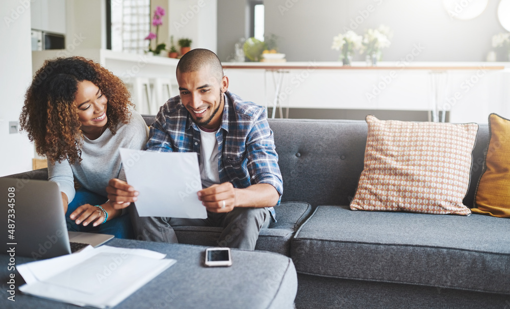 Building a tight household budget. Shot of a young couple going through their paperwork together at 