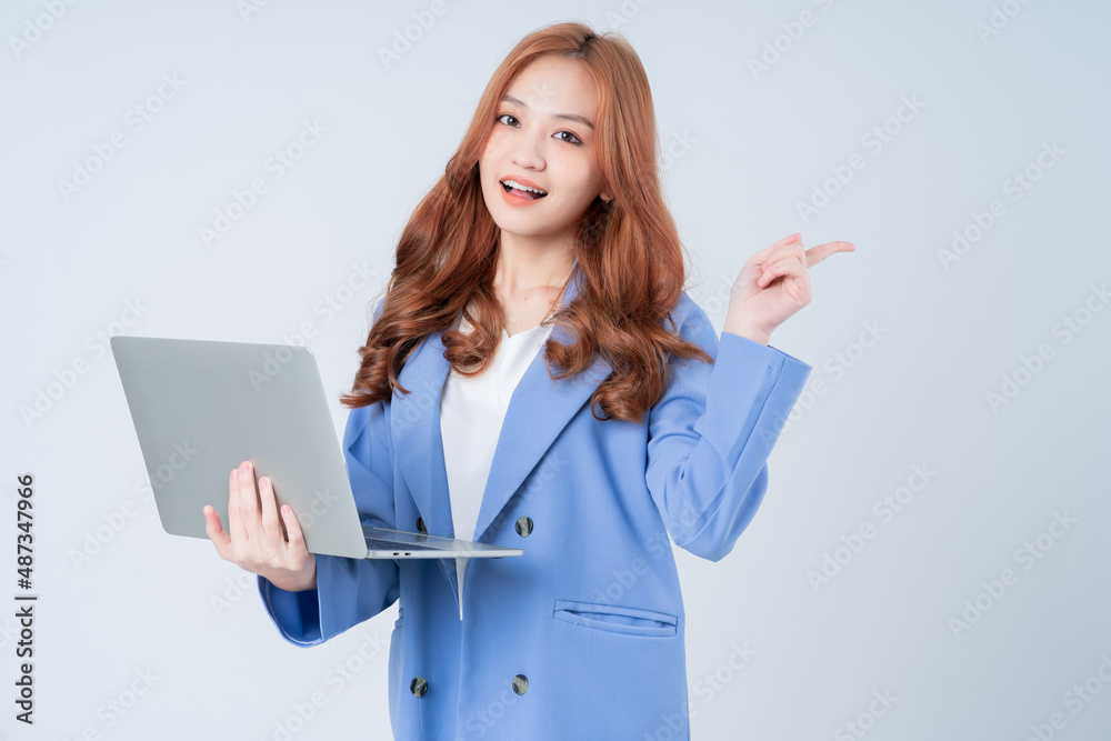 Young Asian businesswoman using laptop on white background