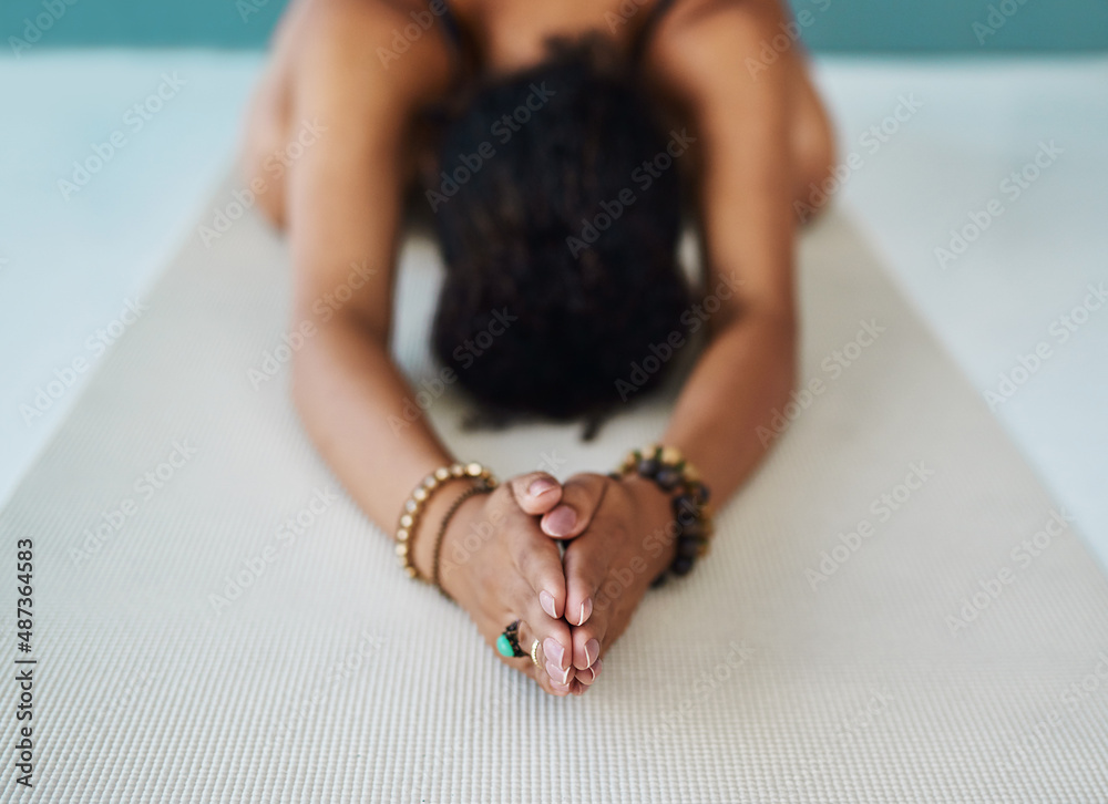 Going through her yoga routine. Cropped shot of a young woman practising yoga.