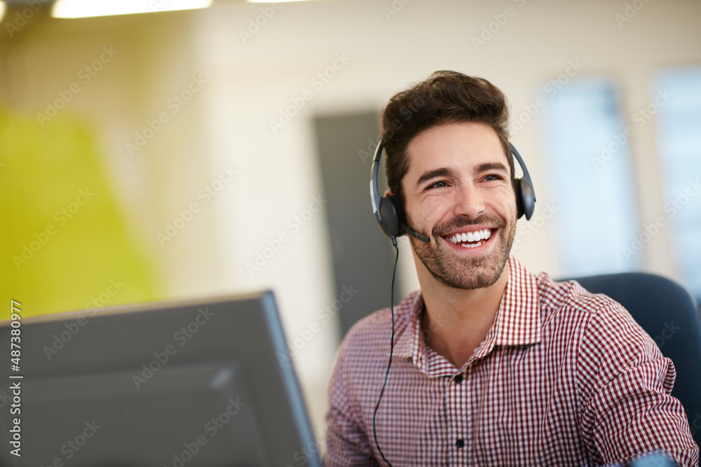 Pleasure in the job puts perfection in the work. Shot of a friendly young call centre agent sitting 