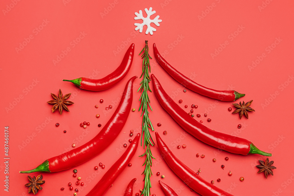 Christmas tree made of hot chili peppers and spices on red background