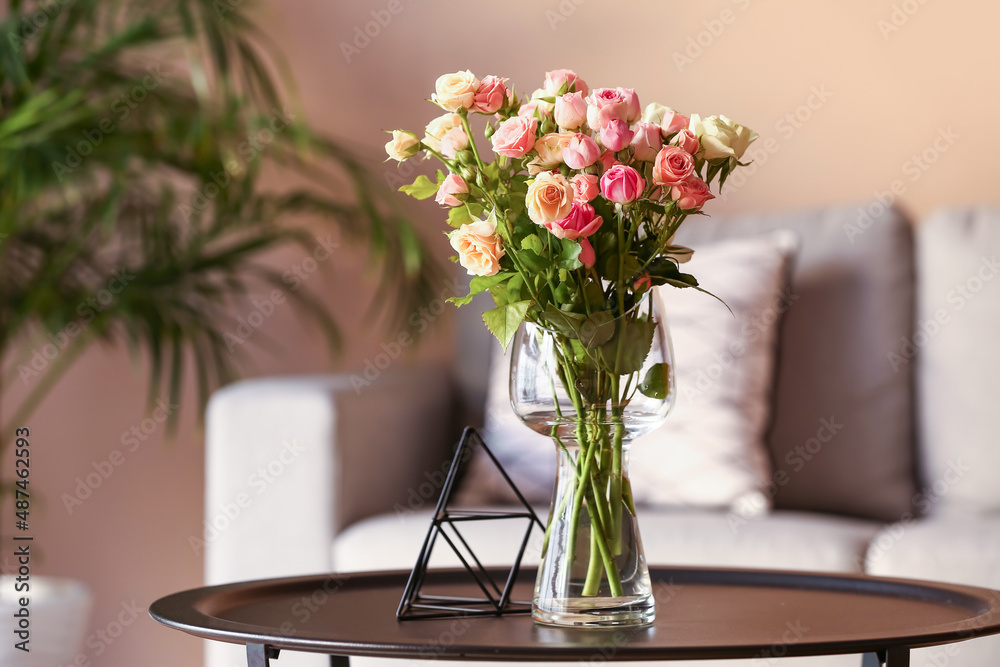 Vase with beautiful roses on table in room