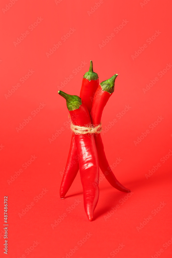 Bundle of hot chili peppers on red background