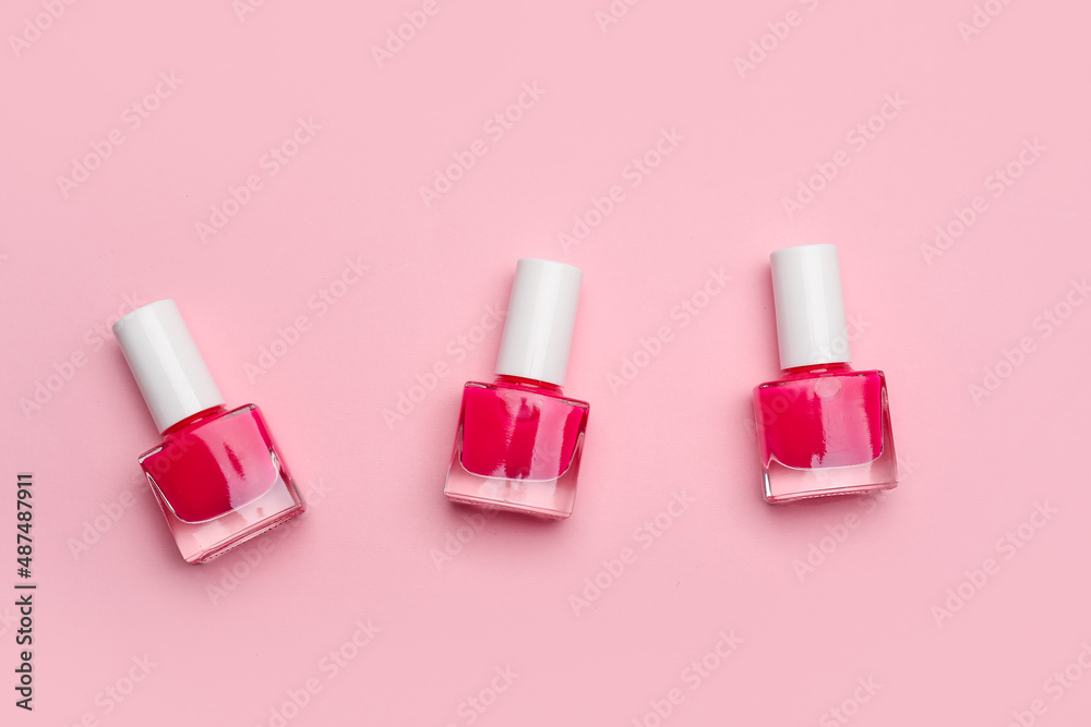 Nail polish bottles on color background