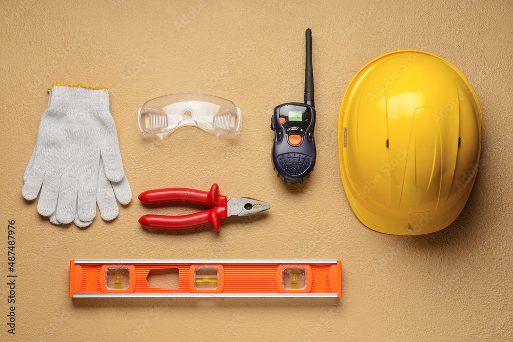 Safety equipment with builders tools and radio transmitter on color background