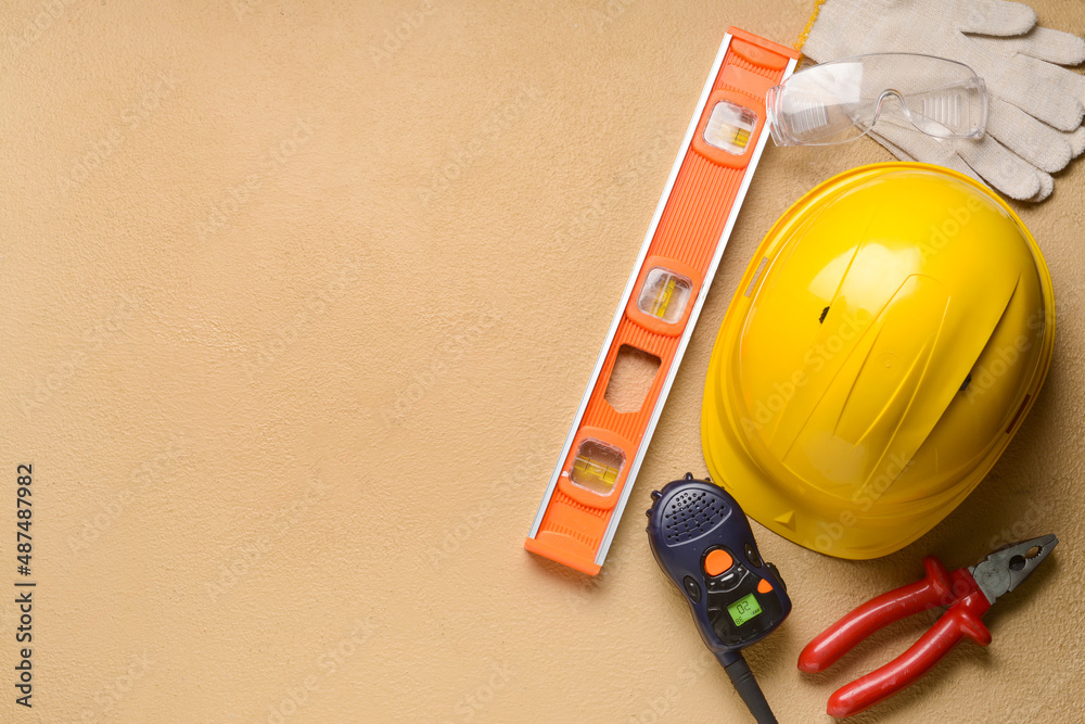 Safety equipment with builders tools and radio transmitter on color background