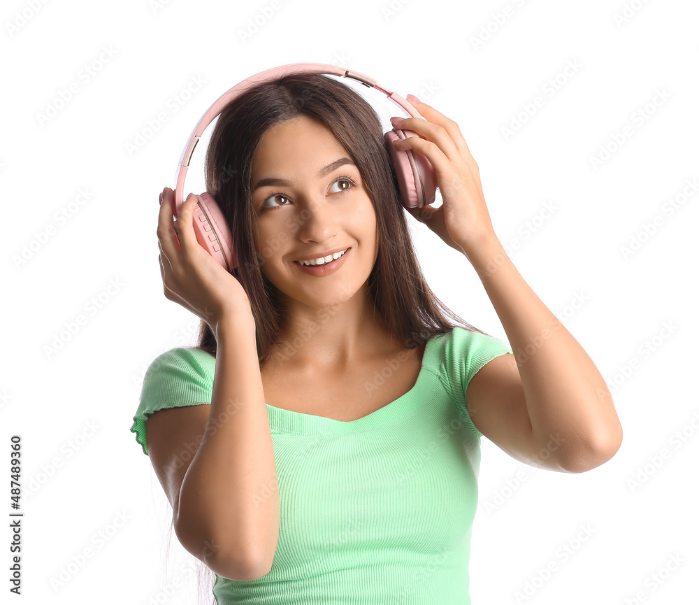 Cool young woman listening to music on white background