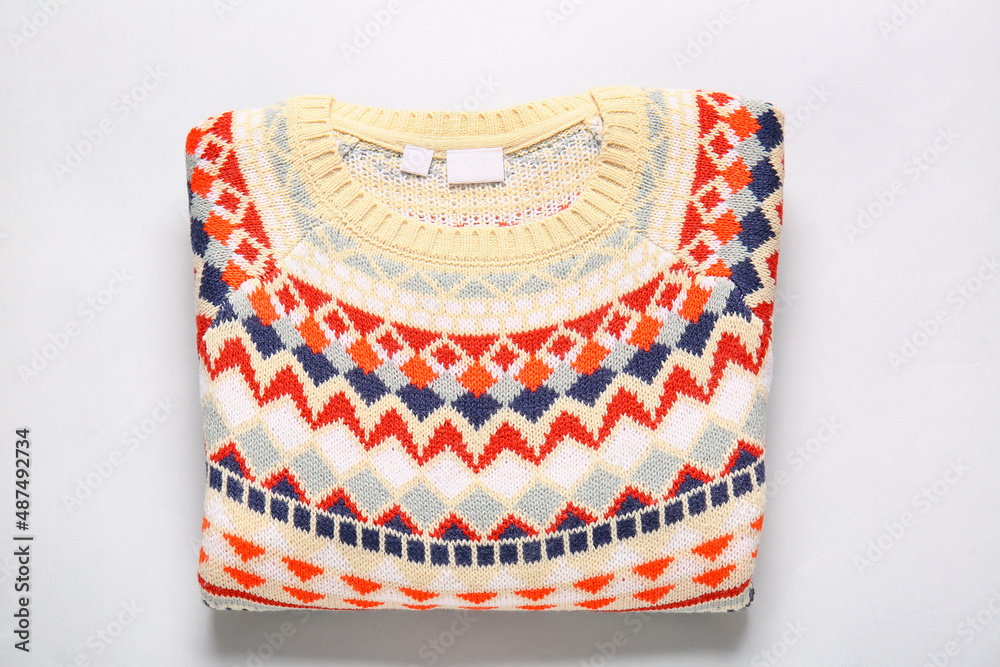 Warm sweater with stylish pattern on grey background