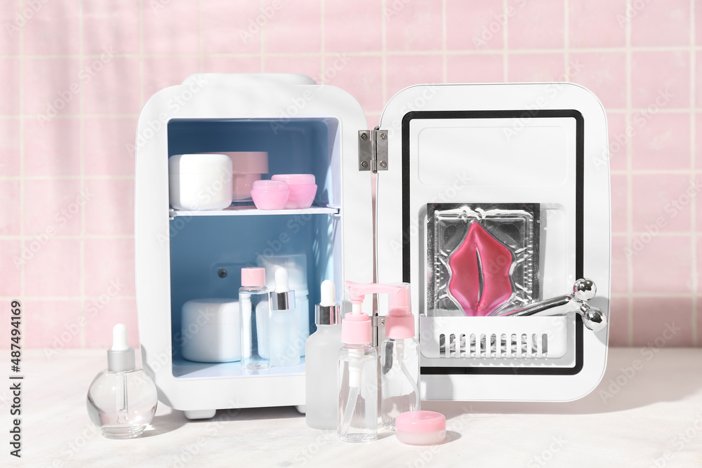 Small refrigerator with cosmetic products on table