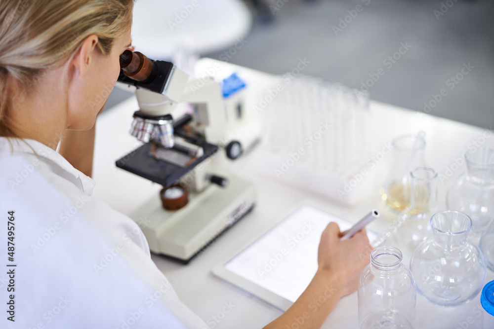 Research is nothing with records. Shot of a beautiful young scientist recording her findings on a ta