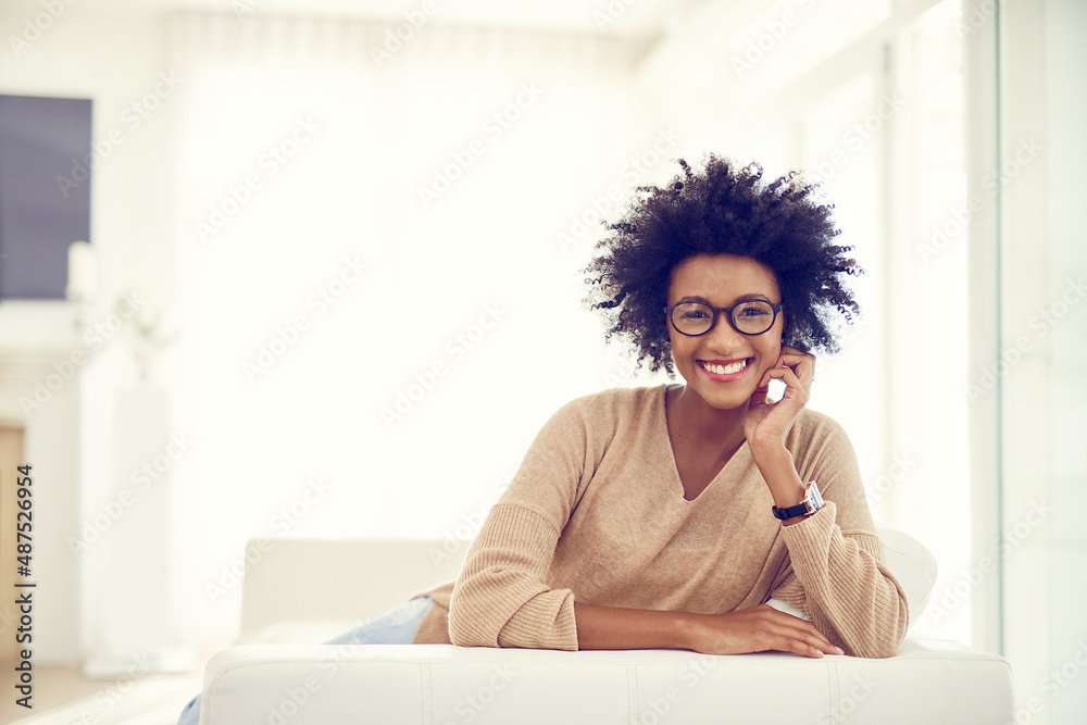 Home is the comfiest place to be. Portrait of a happy young woman relaxing at home.