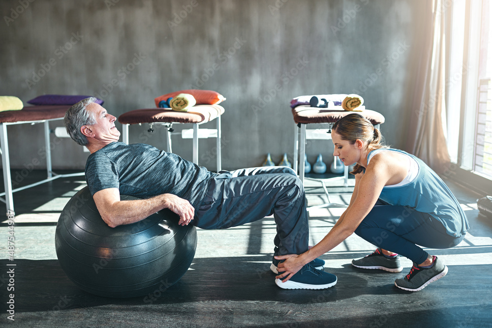 Time to get up and get moving. Shot of a senior man working out with his physiotherapist.