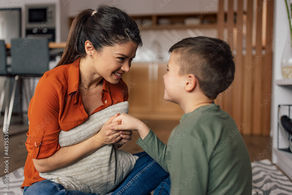 Mothers day, lovely pony-tailed brunette woman, holding her sons hand.