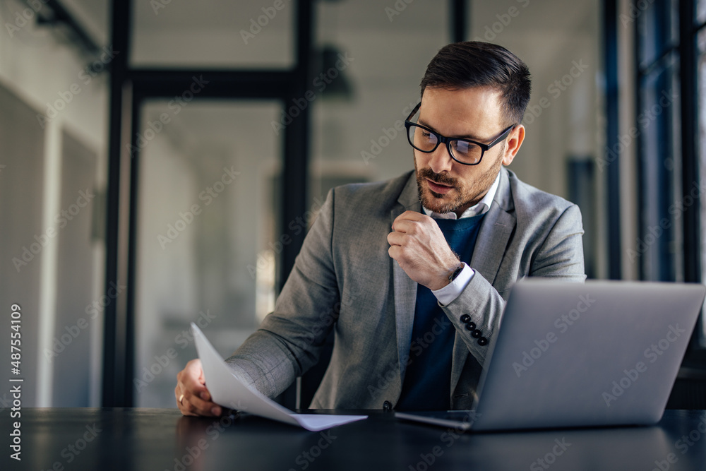 Hardworking caucasian man, reading a file, thinking what to do next.