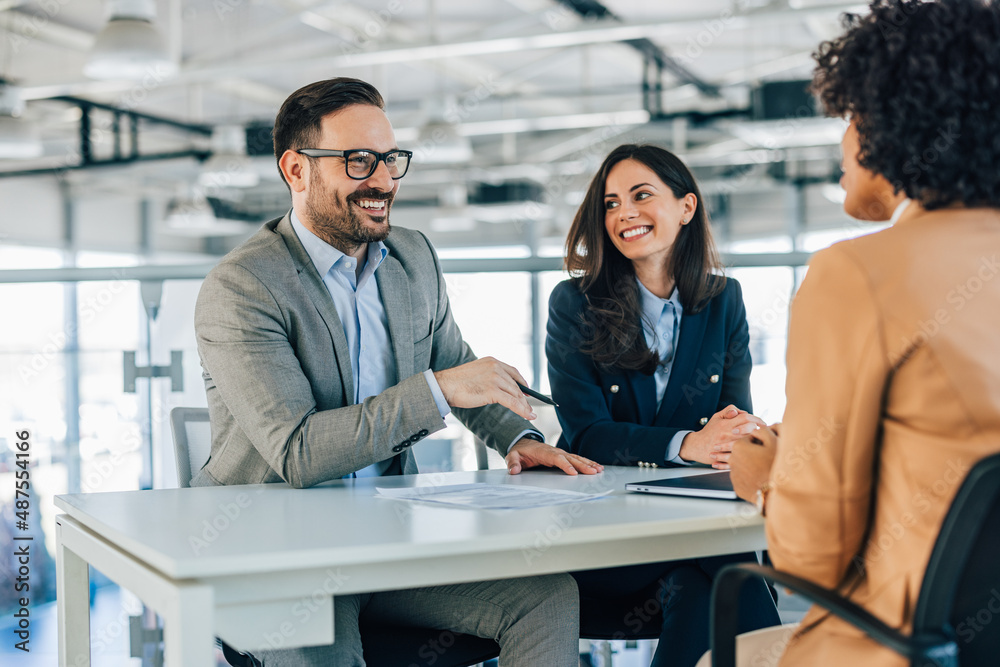 Businessman and businesswoman having a meeting with one customer.