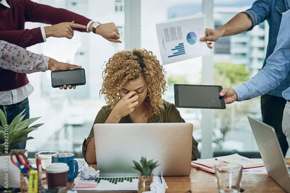 Work commitments are closing in on her. Shot of a young businesswoman looking stressed out in a dema