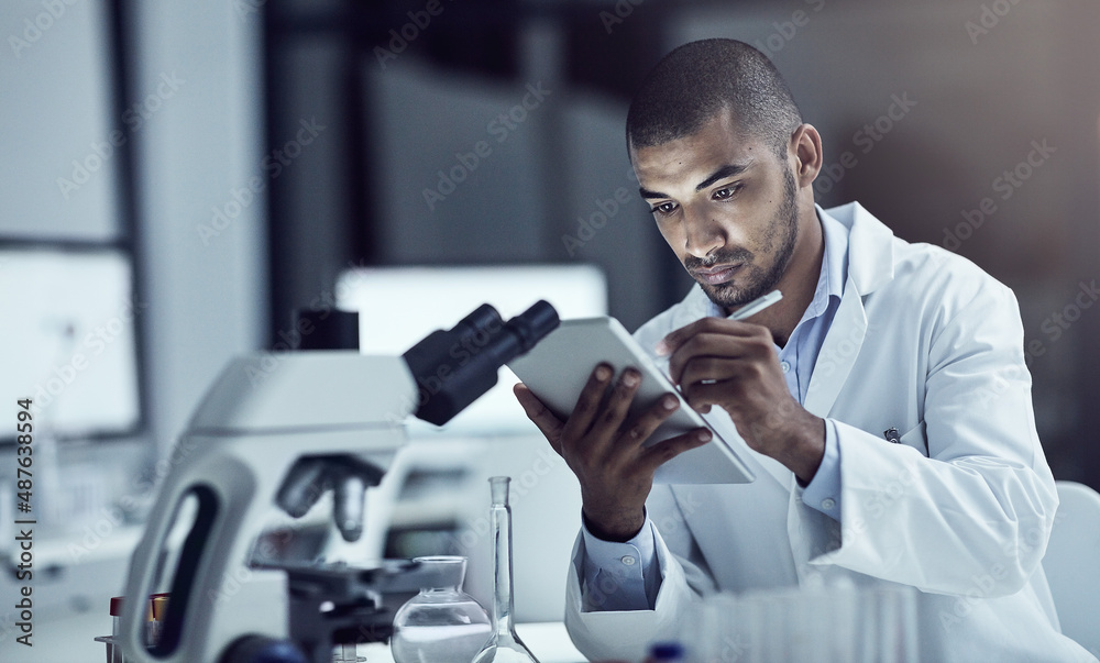 Announcing his findings to the world. Shot of a scientist recording his findings on a digital tablet