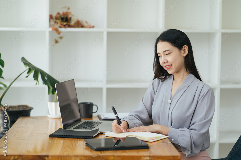 漂亮的年轻自由职业女性坐在咖啡桌旁用笔记本电脑。快乐的微笑女孩Wor