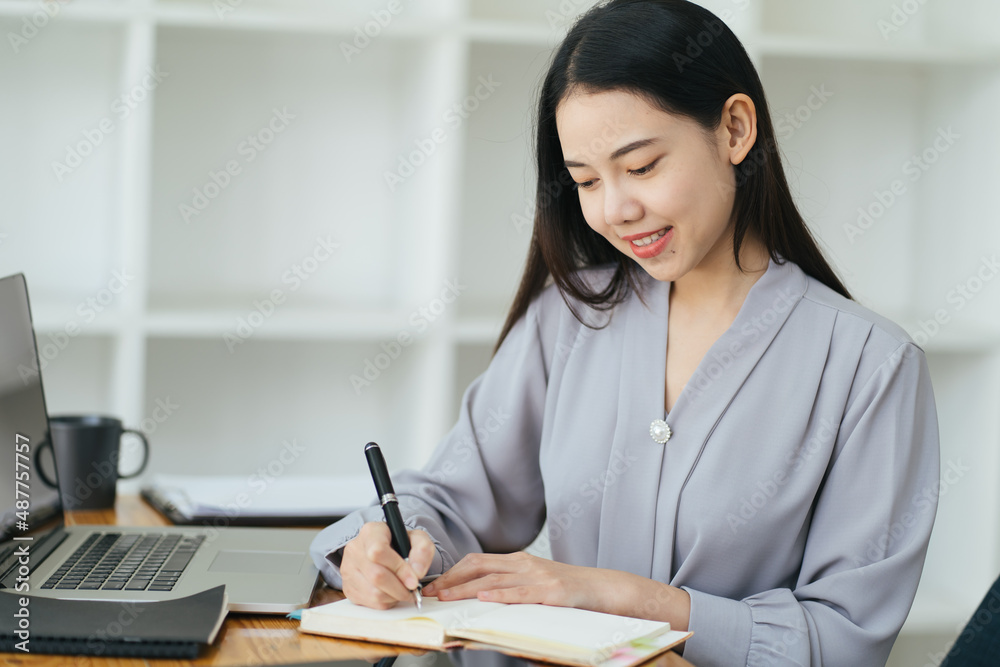 美丽的年轻自由职业女性坐在咖啡桌旁用笔记本电脑。快乐的微笑女孩Wor