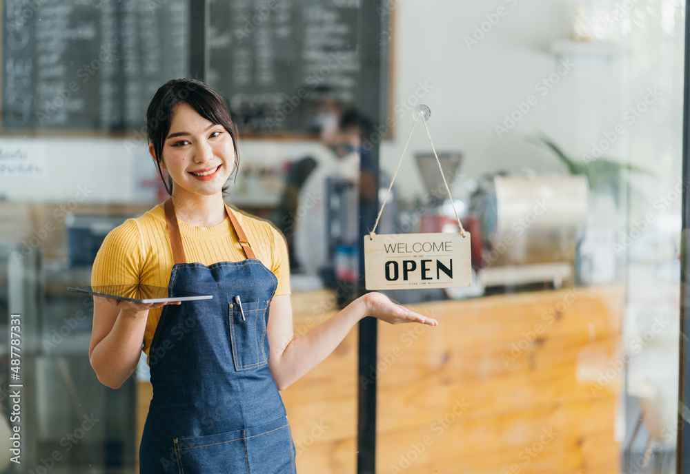 Portrait of a happy waitress standing at restaurant entrance. Portrait of mature business womanatten