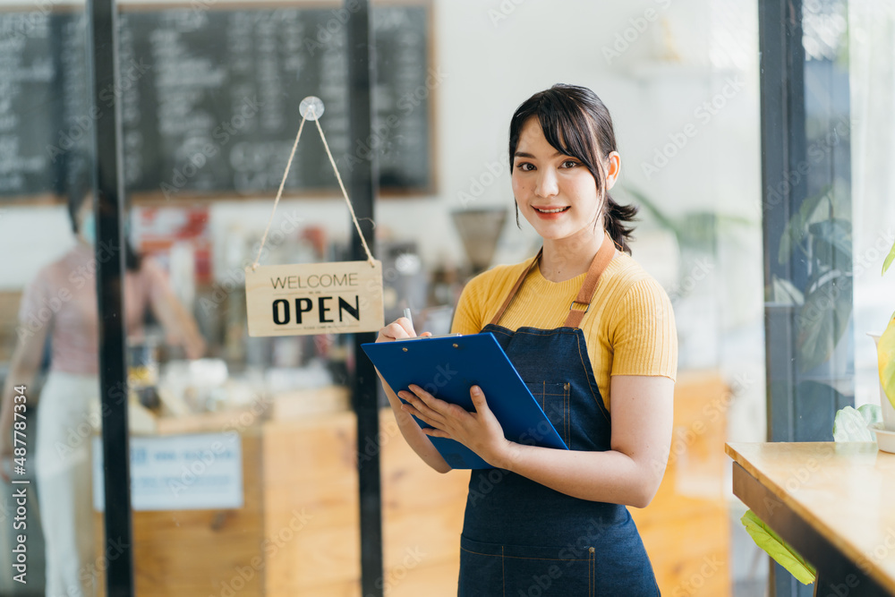 Portrait of a happy waitress standing at restaurant entrance. Portrait of mature business womanatten