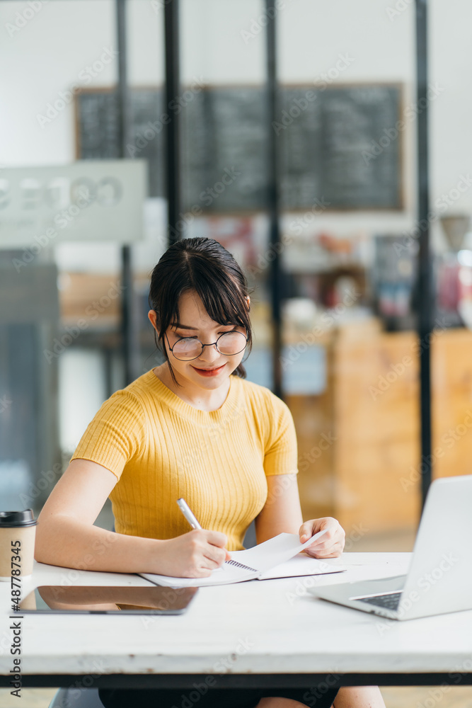 Portrait of charming woman looking at camera during studying on laptop at coworking space, beautiful