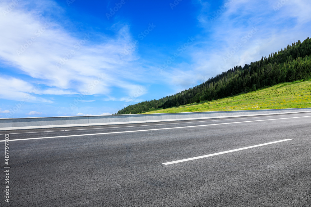 Asphalt road and mountain nature landscape under blue sky