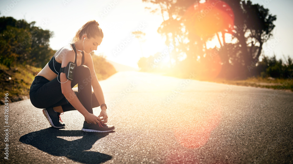 Lace up and get your head in the fitness game. Shot of a fit young woman tying her shoelaces before 