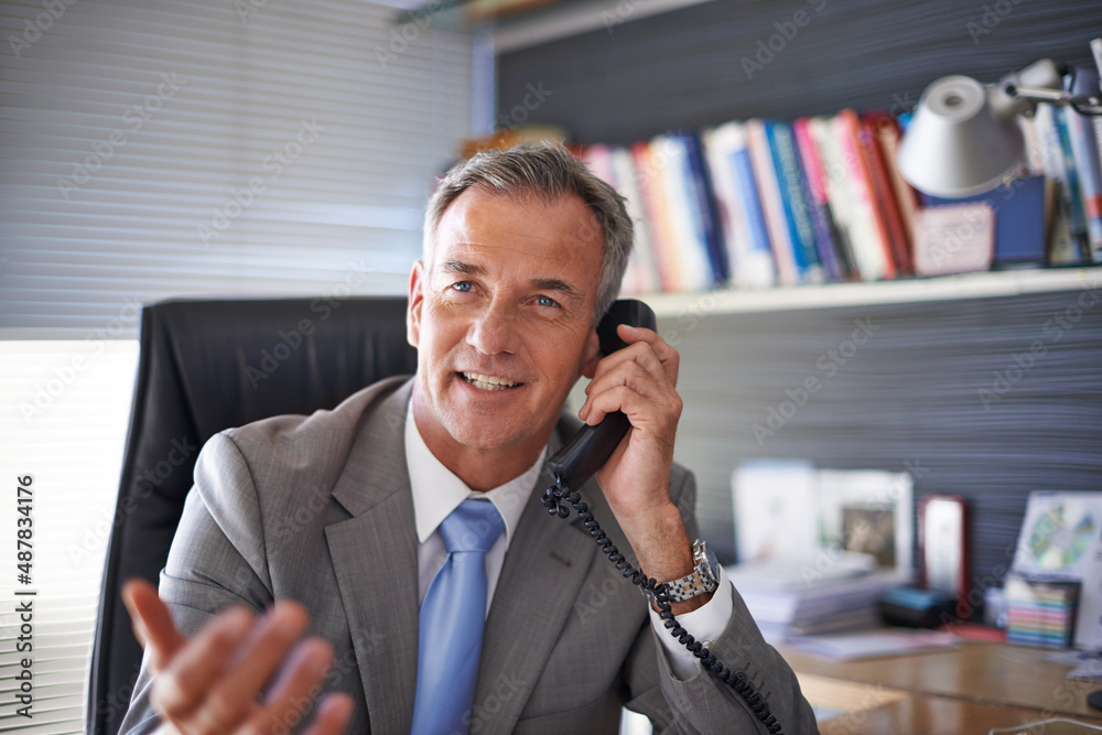 He just received some great news. Shot of a mature businessman looking pleased while talking on the 