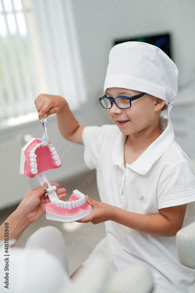 Mouth healthcare little dentist boy in medical suit. Oral child dental uniform.