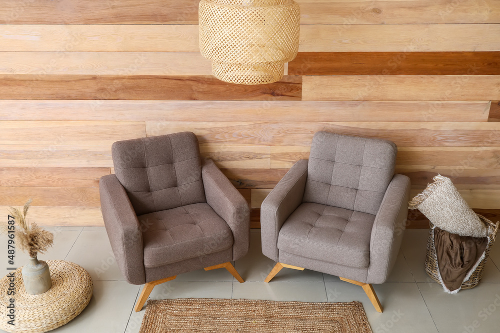 Interior of stylish living room with soft armchairs and hanging lamp