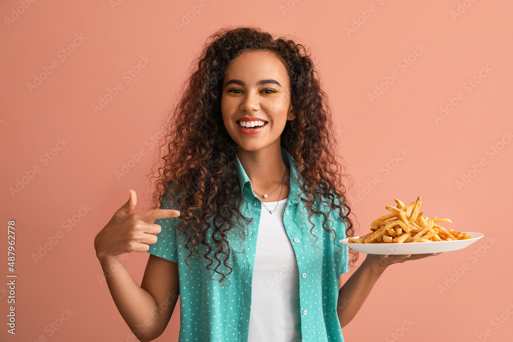 Young African-American woman with french fries on color background