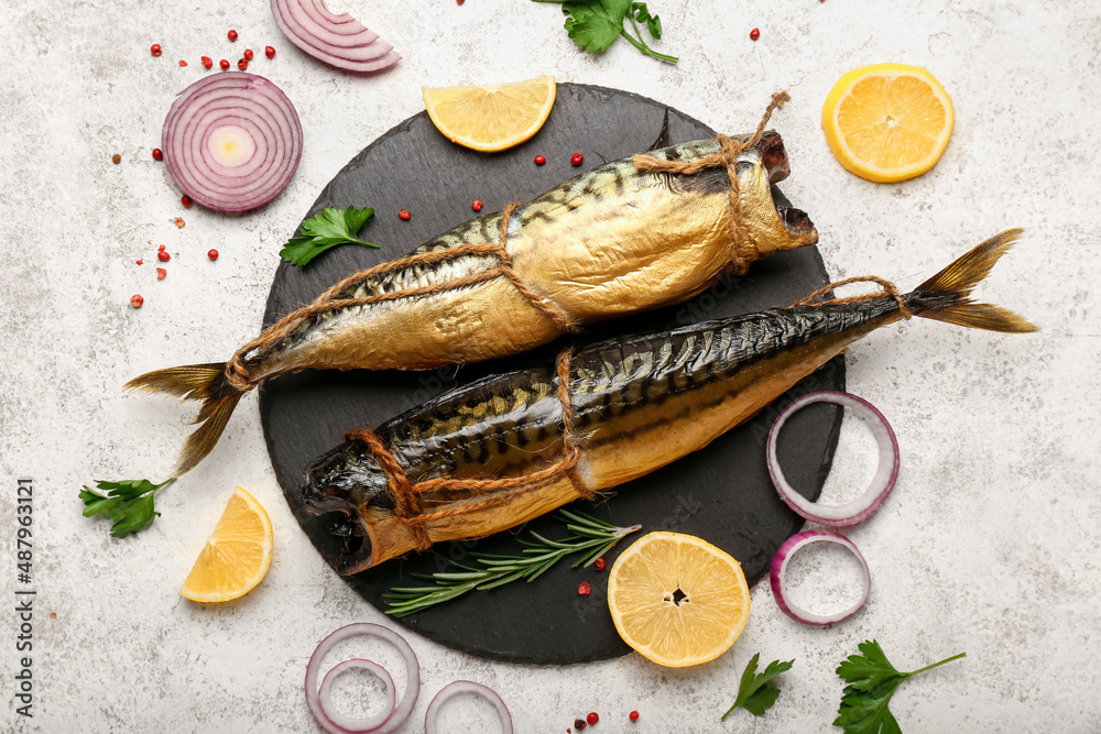 Board with tasty smoked mackerel fishes on light background