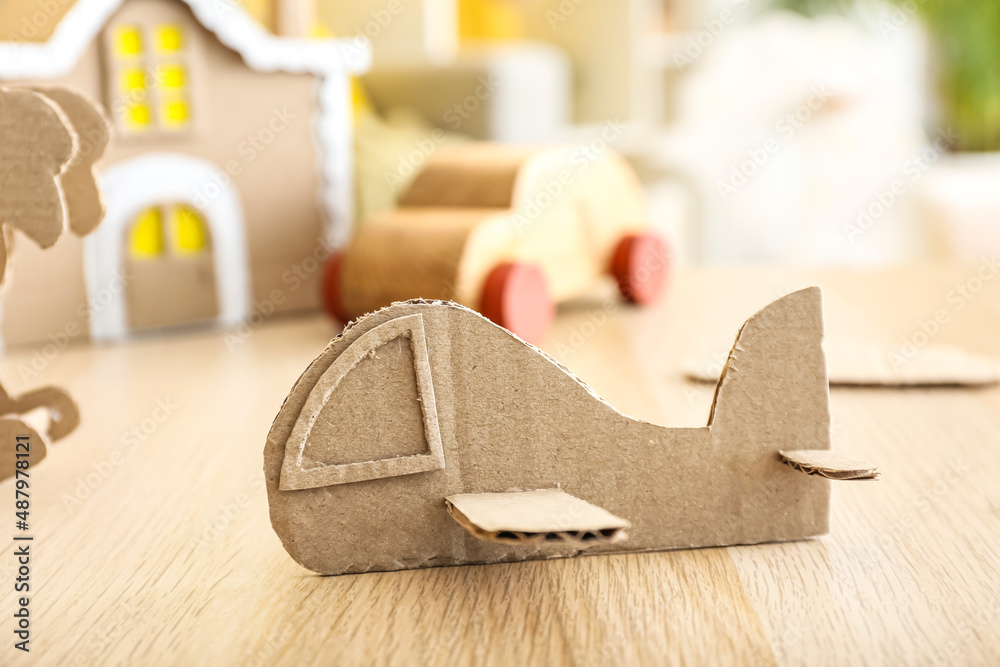 Handmade cardboard plane on wooden table