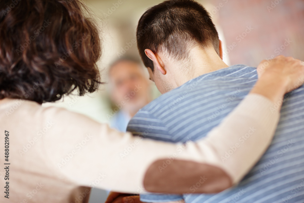 Were all here for you. A rear view shot of a caring mother consoling her adult son.