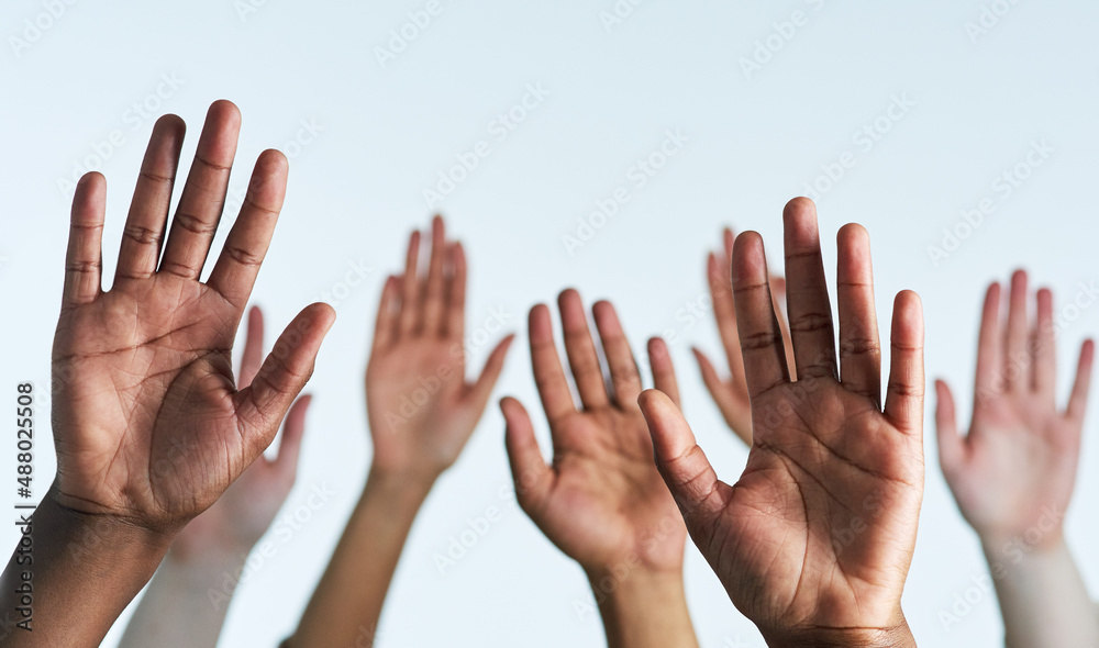 Raise your hands as one. Shot of a group of hands reaching up against a white background.