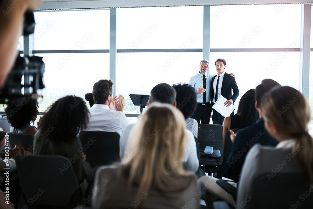 Recognizing excellence in the workplace. Shot of businesspeople applauding a colleague during a conf