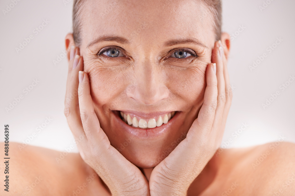 Shes still radiantly beautiful. Studio portrait of a happy mature woman posing with her head in her 