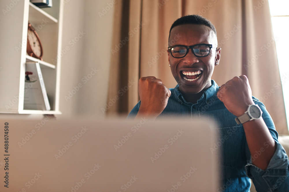 This is the best news ever. Cropped shot of a handsome young businessman sitting alone in his home o