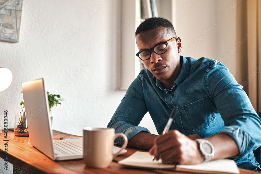 Note taking helps me remember better. Cropped shot of a handsome young businessman sitting alone in 