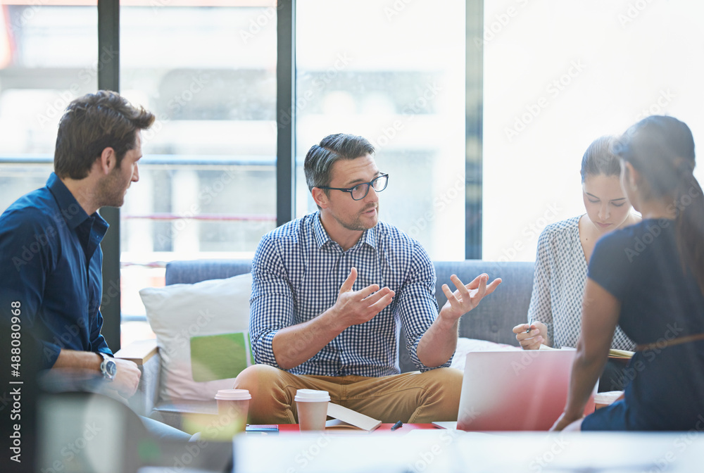 Solutions are a group effort. Shot of a group of office workers talking together in a meeting room.