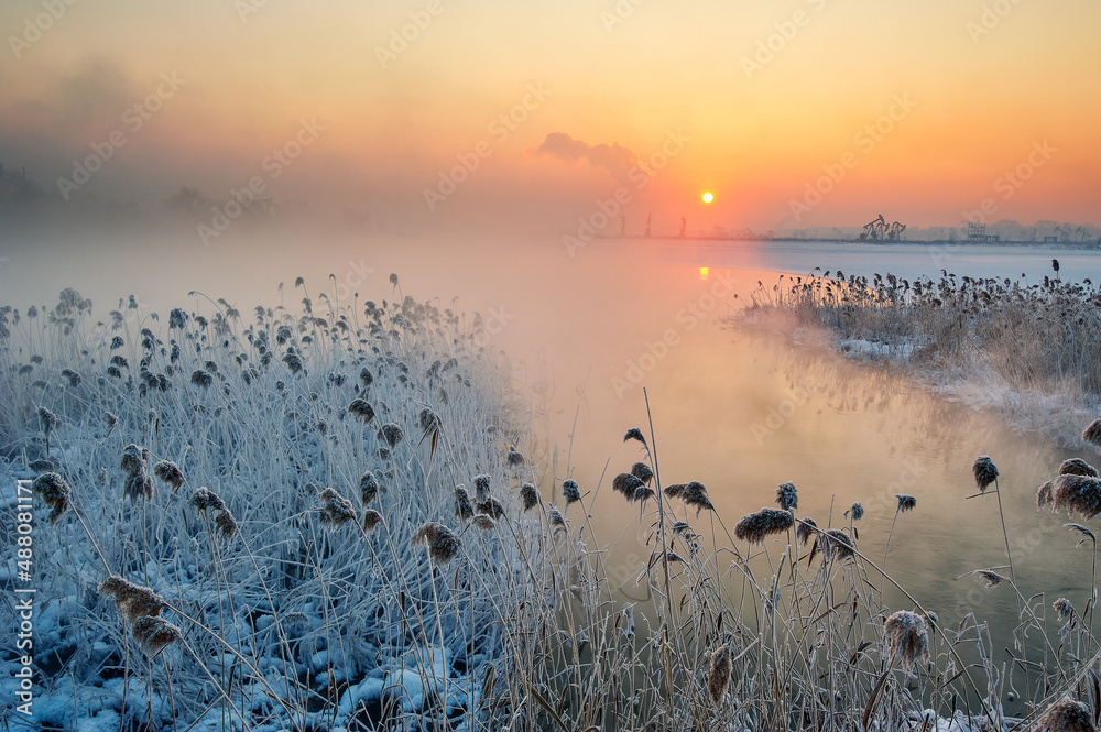 The  oil sucking machines at lakeside sunrise in Daqing oil fields, China.