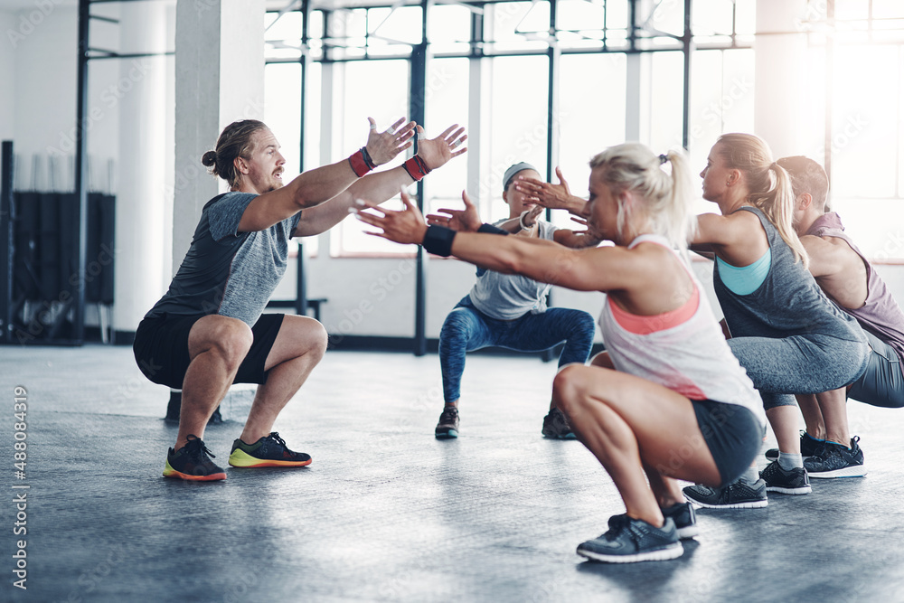 Hes the one to get you in shape. Shot of a fitness instructor working with a group of people at the 