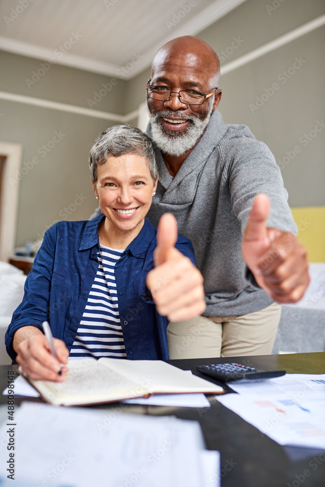 我们的财务状况不错。一对老年夫妇在工作时向你竖起大拇指的裁剪照片